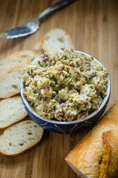 a bowl filled with food next to sliced bread