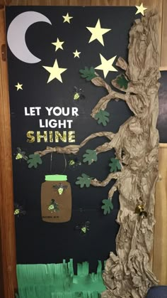 a bulletin board with trees and stars in the background that says let your light shine