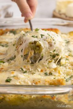 a person scooping cheese from a casserole dish