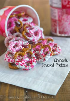 some pretzels are sitting on a napkin next to a can of chocolate covered pretzels