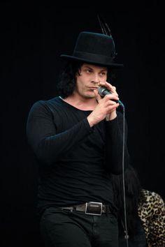 a man in a black hat holding a microphone