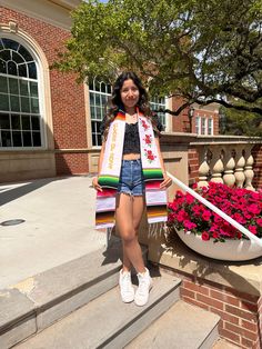 a woman is standing on the steps with her shopping bags in front of some flowers