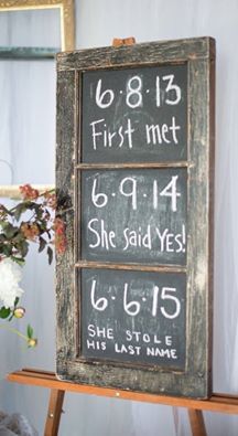 a wooden sign with numbers on it sitting next to a potted plant and mirror