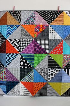 a multicolored patchwork quilt hanging on a wall