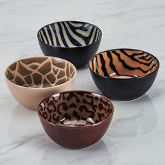 three bowls with different designs on them sitting on a marble counter top next to each other