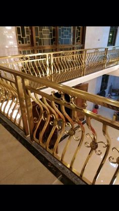 an iron and gold railing in front of a building