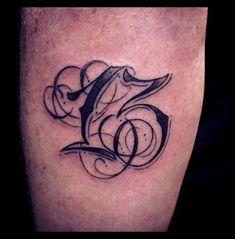 a black and white photo of a tattoo on someone's leg with the letter e in it