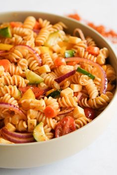 a white bowl filled with pasta salad on top of a table