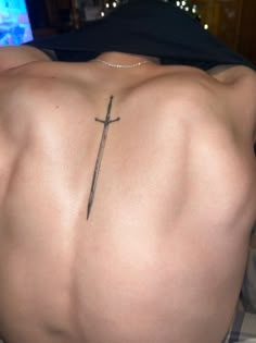 a man with a cross tattoo on his back