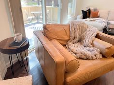 a brown leather chair with a blanket on it