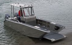 a boat that is sitting on the sand in the water with it's door open