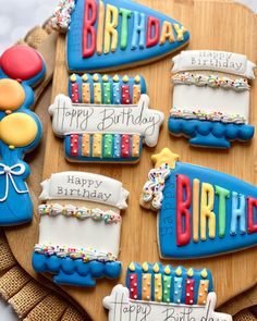 decorated birthday cookies sitting on top of a wooden tray