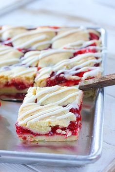 strawberry shortcakes with white icing on a baking sheet, ready to be eaten