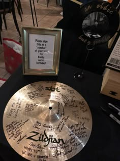 a drum with signed notes on it sitting next to a framed photo