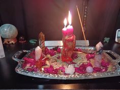 a tray with candles and flowers on it