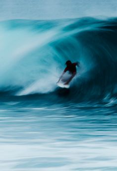 a man riding a wave on top of a surfboard in the middle of the ocean