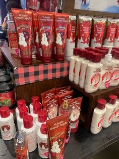 many different types of body lotions on display in a store with red and white decorations