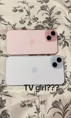 two pink and white iphones sitting next to each other on top of a bed