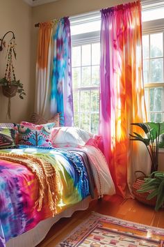 a bedroom with tie - dyed bedding and potted plants in the window sill