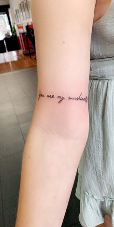 a woman with a tattoo on her arm that says you are my sunshineflowers