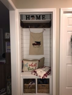 an entry way with some pillows and blankets on the shelf next to it in front of a door