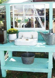 a sink and some potted plants in front of a building with a white roof