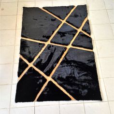 a black area rug on the floor with squares and lines drawn across it in different directions