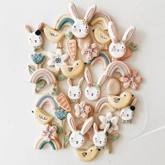 a bunch of cookies that are sitting on a table with bunny ears and rainbows