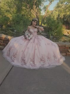 a woman in a pink ball gown posing for the camera with her hand on her hip