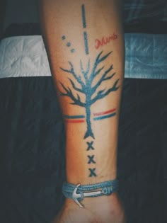 a person with a tattoo on their leg that has a tree and arrows in it