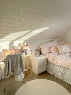 an attic bedroom with white walls and pink bedding on the bottom floor, along with a round rug