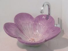 a purple flower shaped sink in a bathroom