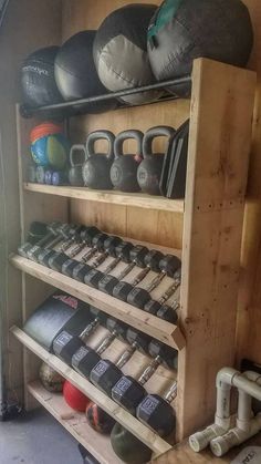 a wooden shelf filled with lots of different types of kettles and dumbbells