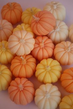 small orange and yellow pumpkins on a white surface