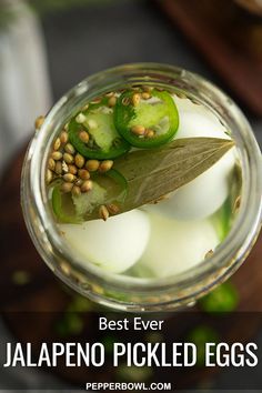 a jar filled with pickled eggs on top of a wooden table