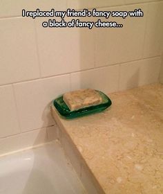 a green plate sitting on top of a bath tub next to a white tiled wall