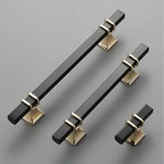 four black and gold door handles on a gray surface