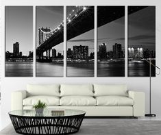 a living room with white furniture and black and white wall art