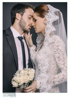 a bride and groom are posing for a wedding photo in front of a gray background