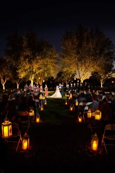 the wedding party is lit up at night with lanterns on the ground and people sitting in chairs