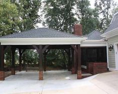 a gazebo in the middle of a driveway surrounded by trees