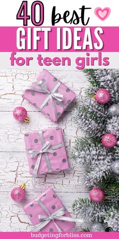 presents with pink and silver bows on them, surrounded by christmas ornaments and pine branches