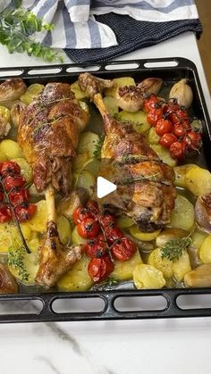 chicken and potatoes on a baking sheet with tomatoes