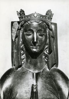 a black and white photo of a statue with a crown on it's head