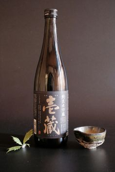 a bottle of wine sitting on top of a table next to a bowl and spoon