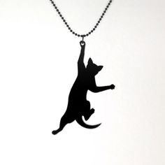 a black cat silhouetted on a ball chain with its paw in the air as if to catch a frisbee