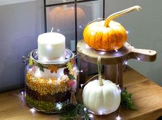 two pumpkins are sitting next to each other on a table with some lights around them