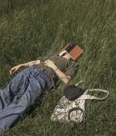 a person laying in the grass with a book