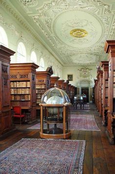 a room filled with lots of wooden furniture and bookshelves on either side of the room