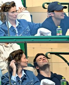 a man and woman sitting next to each other at a tennis match in the stands